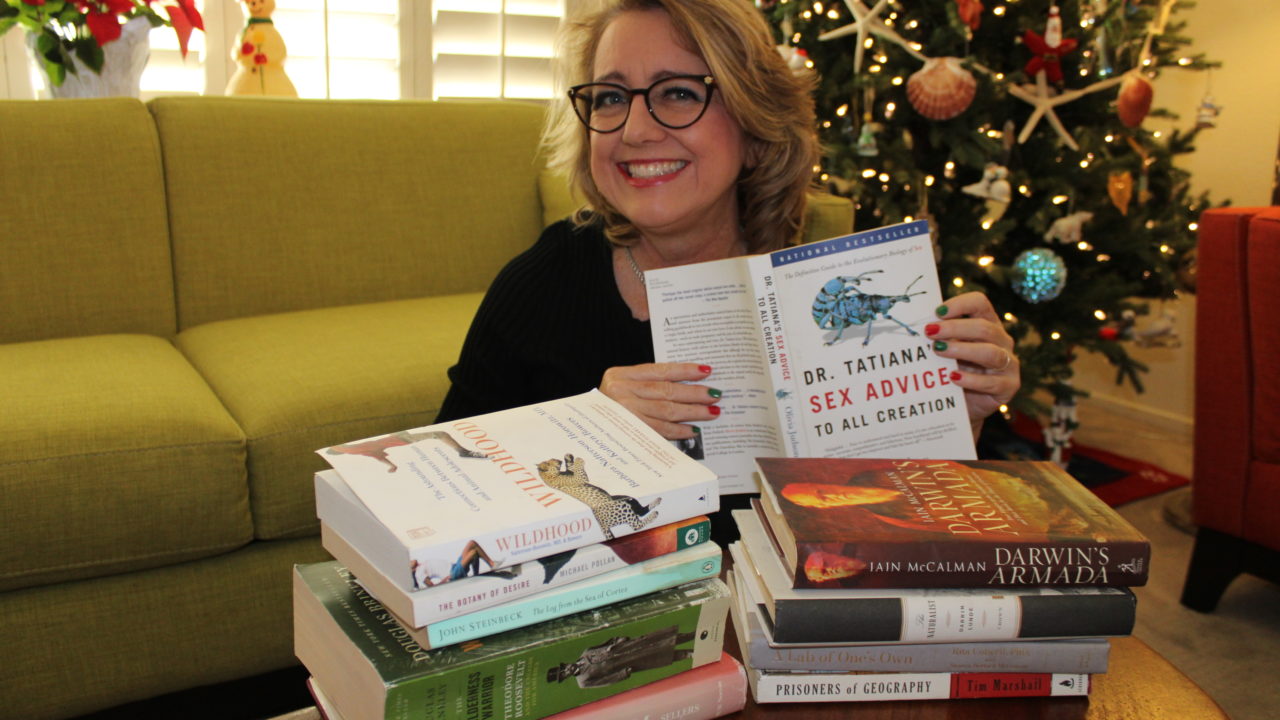 Author with stack of recommended books